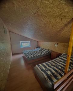 a attic bedroom with two beds and a ceiling at Gościniec rybacki in Dąbki
