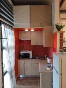 a small kitchen with white cabinets and a microwave at Harmony Sophie's in Néon Rýsion