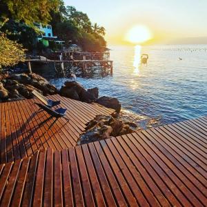 a sunset over a body of water with a dock at Saracura in Praia de Araçatiba