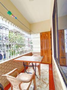 Habitación con mesa, sillas y ventana en Modern 3 Bedroom Flat in Sylhet en Sylhet