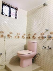 W łazience znajduje się różowa toaleta i prysznic. w obiekcie Modern 3 Bedroom Flat in Sylhet w mieście Srihotto