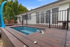 a swimming pool on a wooden deck with a house at Lakefront Getaway in Rotorua in Rotorua