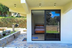 ValZur Hospedaje-Habitación Acacias في فيلا ديل كاربون: غرفة نوم خارج المنزل مع باب زجاجي