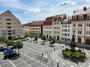 a city square with a fountain and buildings at Hitorischer Charme in Top-Altstadtlage - Fewos Anno 1529 in Zittau