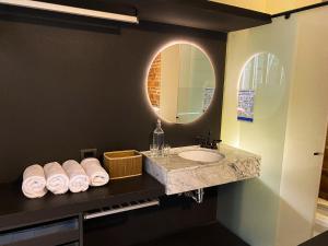 a bathroom with a sink and a mirror and towels at Casa Charlotte - Alma Hotels in Santa Marta