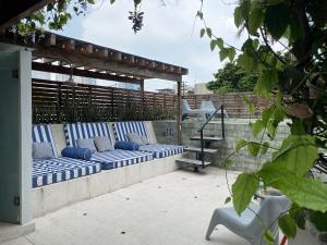 eine Terrasse mit blauen und weißen Kissen auf einer Bank in der Unterkunft Casa Charlotte - Alma Hotels in Santa Marta