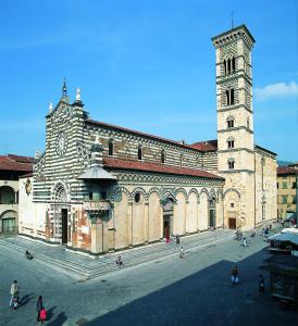 un grand bâtiment en briques avec une tour et une église dans l'établissement Taverna abitazione a 15 km da Firenze, à Prato