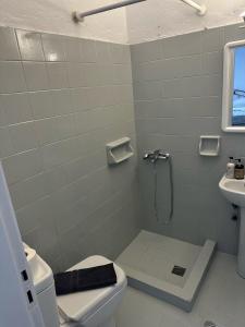 e bagno con doccia, servizi igienici e lavandino. di Santorini Style Rooms a Vóthon