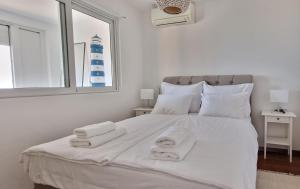 - une chambre avec un grand lit blanc et des serviettes dans l'établissement Moonlight apartment, à Matulji