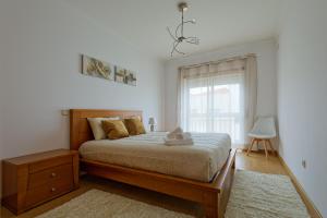 ナザレにあるAlojamento Santo António IIの大きなベッドと窓のある寝室