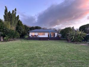 a house with a large lawn in front of it at Lakefront Getaway in Rotorua in Rotorua