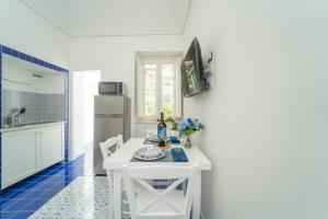 een keuken met een witte tafel en een koelkast bij Relais Capitolo in Maiori