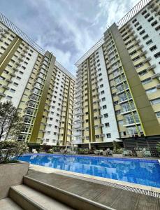 zwei große Apartmentgebäude mit einem Pool davor in der Unterkunft Mesaverte Residences T2-8H in Cagayan de Oro