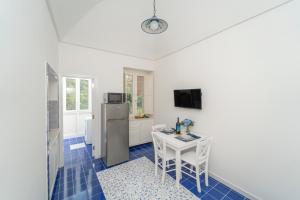 a kitchen with a table and a refrigerator at Relais Capitolo in Maiori