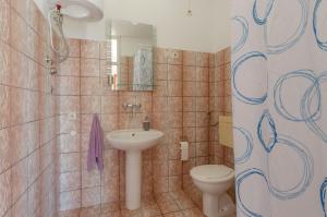 une salle de bain avec un lavabo et des toilettes dans l'établissement Apartments Olivera, à Potirna 76 autres photos