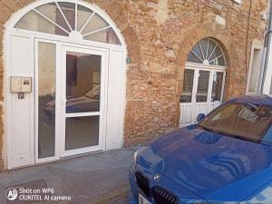 a blue car parked in front of a building at La Pierre n°3 en Centre Ville in Tartas