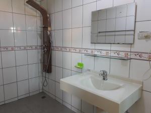 een witte badkamer met een wastafel en een spiegel bij Beido Qixing in Beidou