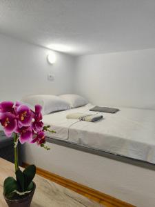 Un dormitorio con una cama blanca y una flor morada en Sutorange, en Sutomore