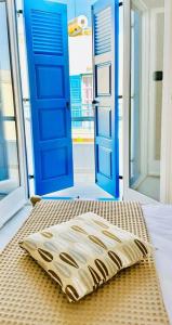 een kussen op een bed voor een deur bij D & K Suite Naxos Town in Naxos Chora