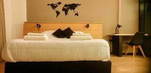 a bedroom with a white bed with a world map on the wall at Alsina Suite!! Hermoso y moderno apart en Salta!! in Salta