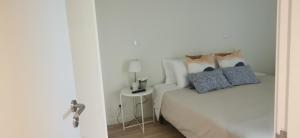 um quarto com uma cama e uma mesa com um abajur em Vista Mar em Viana do Castelo