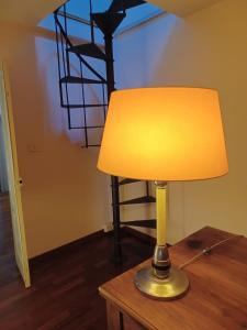 una lampada posta sopra un tavolo di legno di residenza Al Duomo a Parma