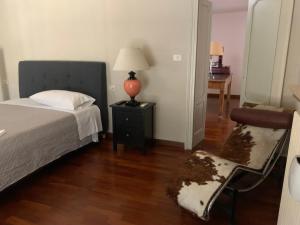 a bedroom with a bed and a chair and a table at residenza Al Duomo in Parma