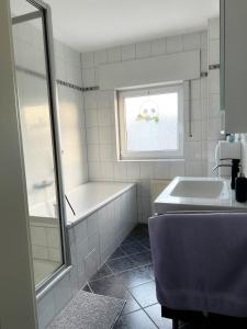 a white bathroom with a tub and a sink at FeWo Gladbeck in Gladbeck