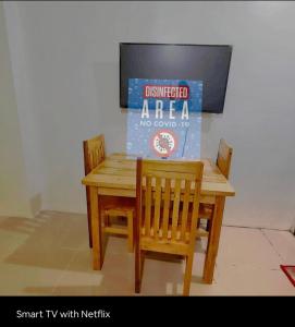 a wooden table and chairs with a sign on it at Condo Stay at Paranaque with Unlimited WIFI v3 in Manila