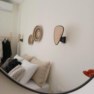 a room with a couch with pillows and a mirror at nisaki rooms & apartments in Methana