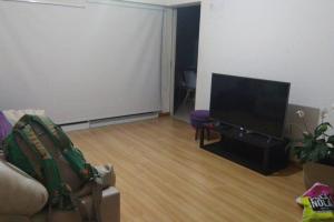 uma sala de estar com um sofá e uma televisão de ecrã plano em Casa con pileta en Rosario em Rosário