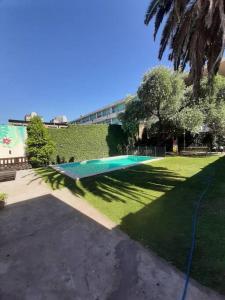 uma piscina num parque com relvado verde em Casa con pileta en Rosario em Rosário