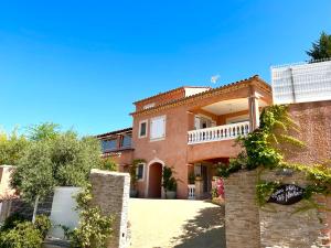 a large brick house with a fence in front of it at Chambres d'hôtes Les Noisetiers in Digne-les-Bains