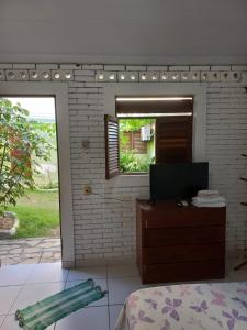 Pousada jardim de cabo branco في جواو بيسوا: غرفة نوم مع مرآة وسرير وخزانة