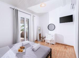 a white bedroom with a bed with a tray of oranges on it at Katerina’s Lux Home in Gerokampos Beach