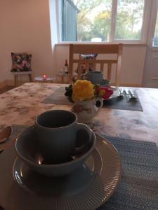 a table with a cup and a plate on a table at Ivy Cottage in Wexford