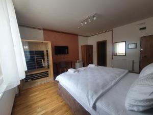 a bedroom with a large white bed and a window at Fruškogorski biser in Sremski Karlovci