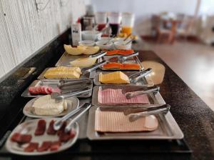 a buffet line with different types of food on plates at Hotel Cabana Jardim de Flores in Gramado +43 photos