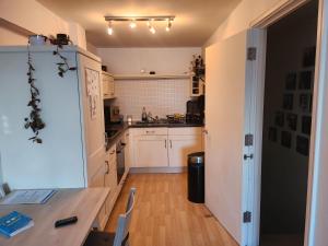 a kitchen with white cabinets and a table in a room at Holiday Let Mistley in Mistley
