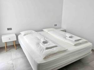 - un lit blanc avec des draps et des oreillers blancs dans l'établissement Weybeach 7 - New, modern, stylish, fully equipped, à La Santa