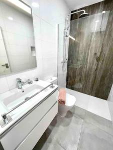 a bathroom with a sink and a shower and a toilet at Weybeach 7 - New, modern, stylish, fully equipped in La Santa