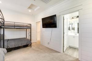 Goodyear Vacation Rental with Private Hot Tub في غوديير: غرفة نوم مع سرير بطابقين وتلفزيون على الحائط