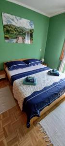 two beds in a green room with towels on them at Aurora on the lake in Fužine +37 photos