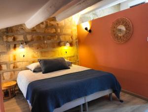 a bedroom with a bed in a stone wall at Maison de village familiale Pont du Gard, toit terrasse, barbecue, Fibre in Vers Pont du Gard