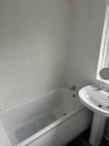 a bathroom with a white tub and a sink at 2 bedroom semi-detached house- sleeps 4 in Newport