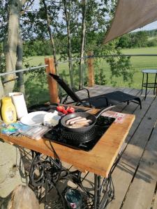 a picnic table with a grill and food on it at Zelený ostroff Treehouse in Jiříkov