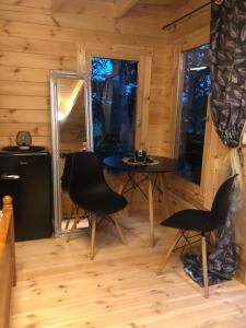 una habitación con mesa y sillas en una cabaña en Zelený ostroff Treehouse, en Jiříkov
