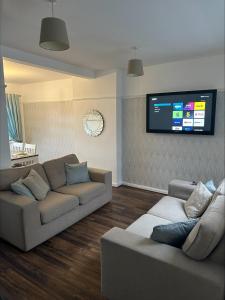 a living room with two couches and a flat screen tv at 2 bedroom semi-detached house- sleeps 4 in Newport