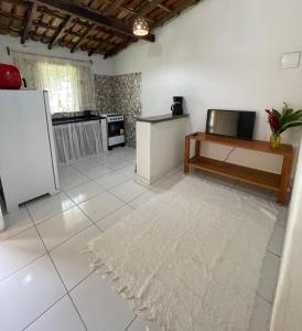 a kitchen with a refrigerator and a table and a rug at Casa Trancoso in Trancoso