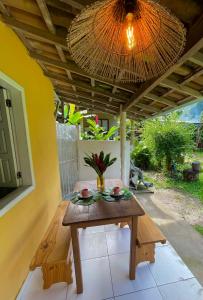 a wooden table on a patio with a ceiling at Casa Trancoso in Trancoso
